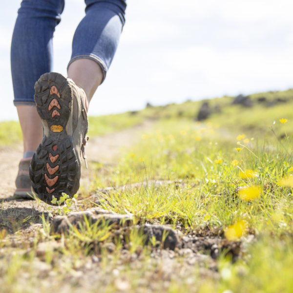 Close up of a person's shoe, walking through green grass